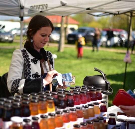 Népviseletbe öltözött hölgy házi szörpöt árul a hatvani vásáron. 2026. 04.04.